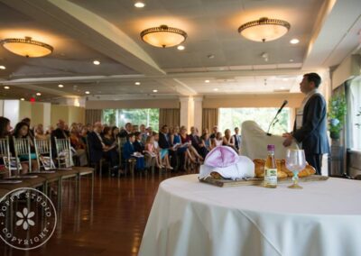 Rabbi Cantor Ron Broden presents a gift to the family of a Bat Mitzvah girl in a synagogue.